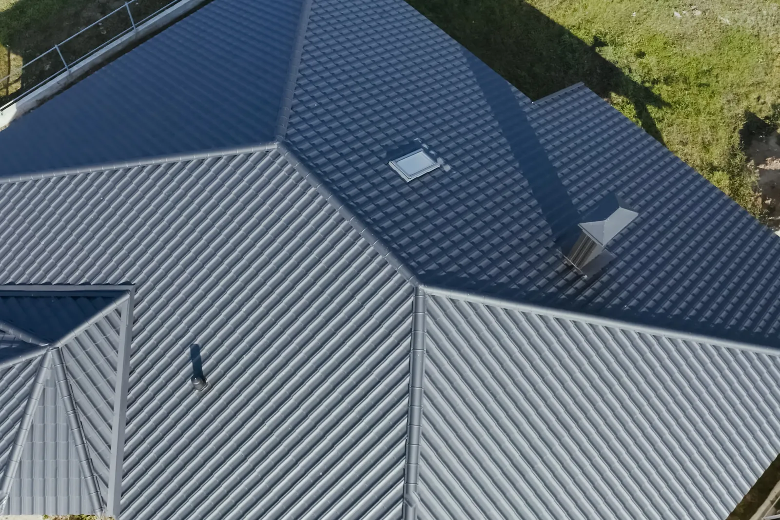 Aerial view of a standing seam metal roof with rooflights and a vent stack in Devizes