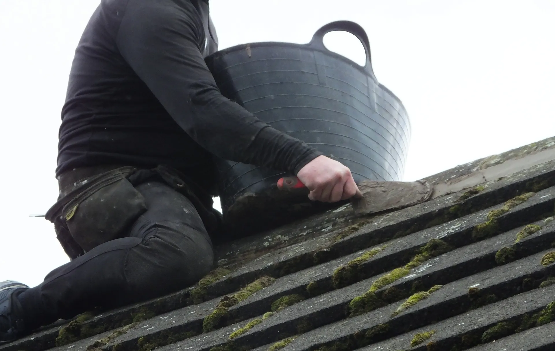 Vanguard Roofing operative sealing a roof ridge with mortar to keep damp out