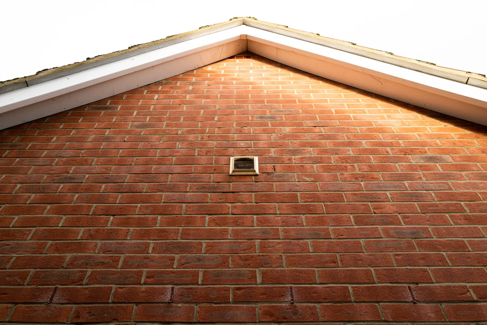 White UPVC bargeboard fitted along a brick gable with an air vent in Devizes