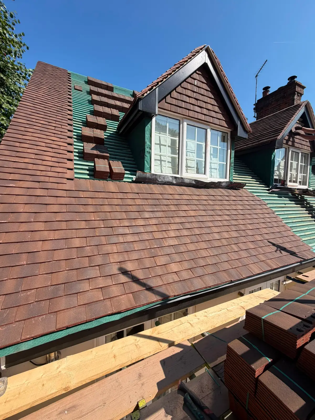 New clay-brown tiled re-roof with tile-hung dormers on a period property in Newbury