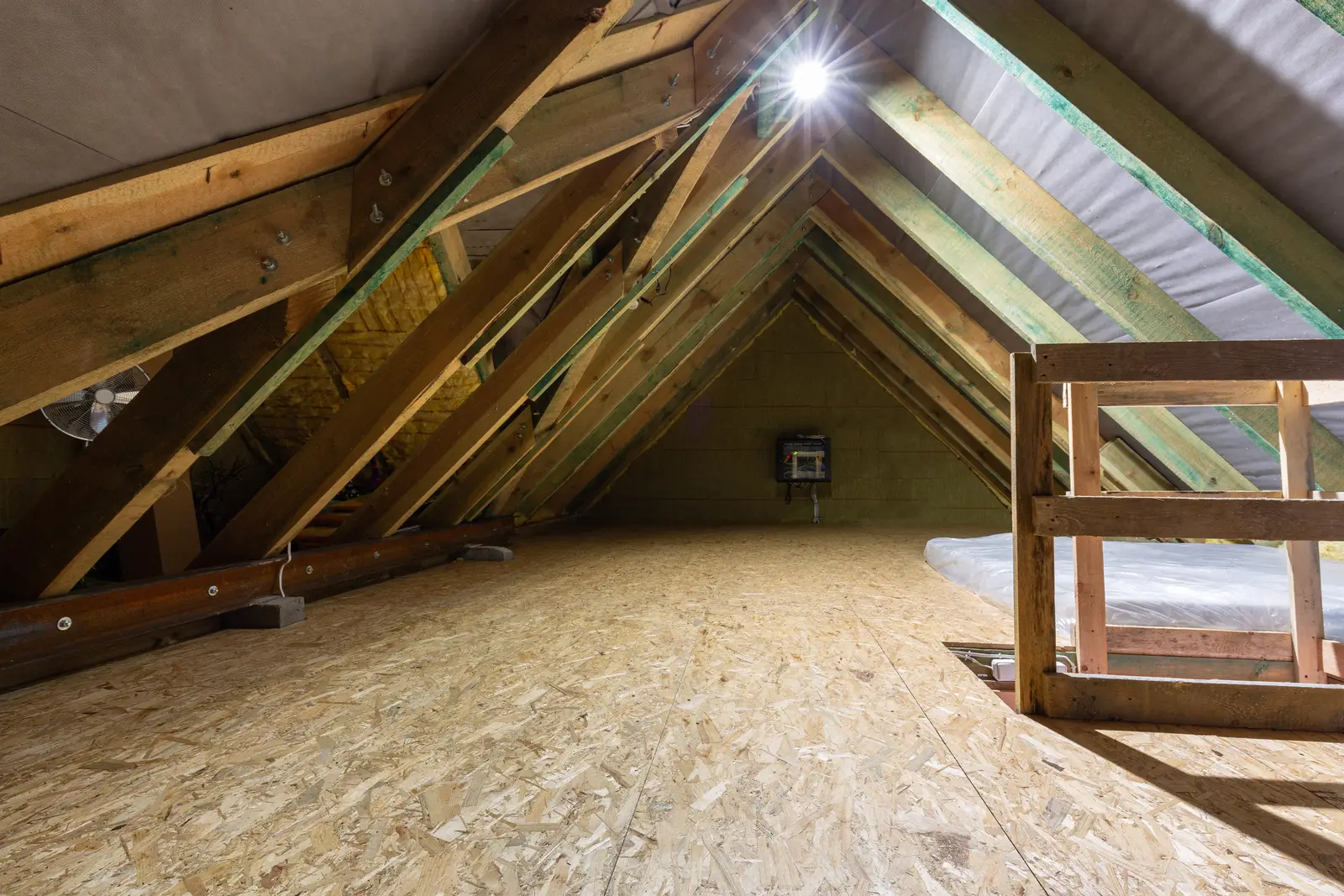 OSB-boarded loft storage platform beneath exposed roof trusses