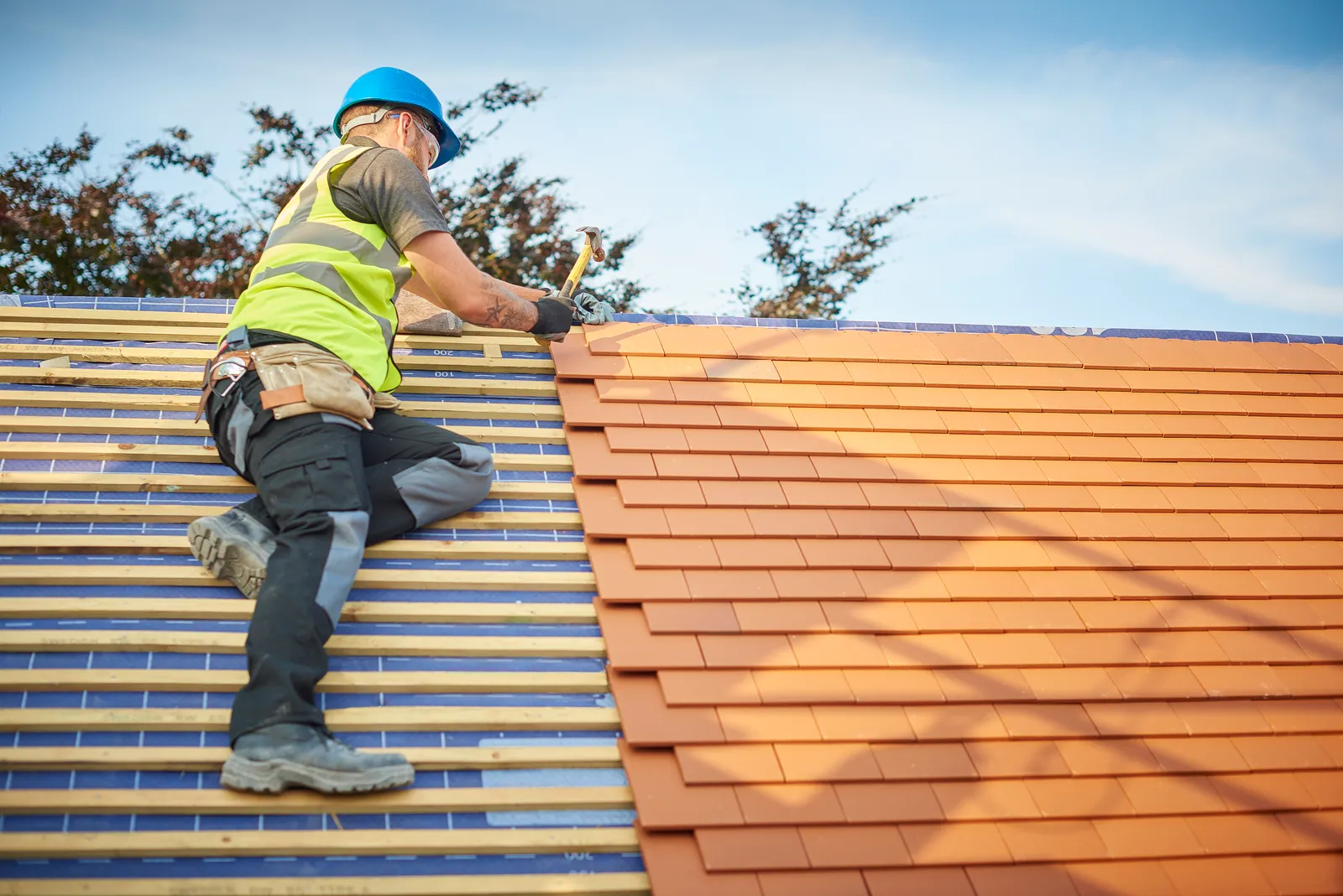 Vanguard Roofing fitting clay tiles on a pitched house roof in Hampshire