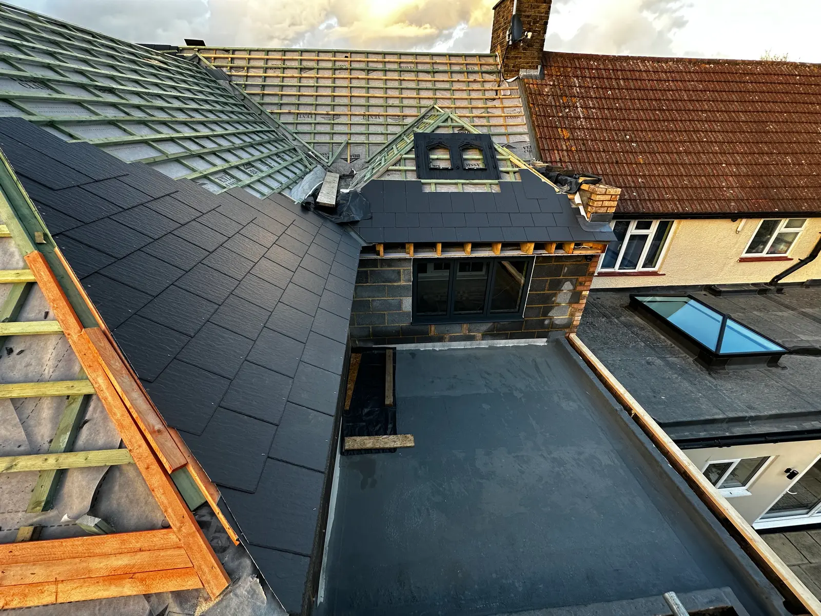 Aerial view of a new slate roof and rear dormer being installed on a house extension in Devizes